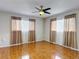 Comfortable bedroom with a ceiling fan, wood-look flooring, and good natural light at 13003 Sandburst Ln, Hudson, FL 34667