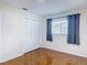 Bedroom featuring tile floors, large window with gray curtains and a closet with louvered doors at 13003 Sandburst Ln, Hudson, FL 34667