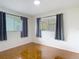 Bedroom featuring tile floors, large windows with curtains, and neutral colored walls at 13003 Sandburst Ln, Hudson, FL 34667