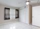 Bedroom featuring tile floors, neutral walls, closet with louvered doors, and a window with patterned curtains at 13003 Sandburst Ln, Hudson, FL 34667