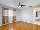 Cozy bedroom with a ceiling fan, wood-look flooring, and natural light from the window at 13003 Sandburst Ln, Hudson, FL 34667