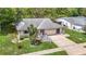 Aerial view of the single-story home with well-maintained lawn, mature trees, and attached two-car garage at 13003 Sandburst Ln, Hudson, FL 34667