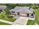 Inviting single-story home featuring a manicured lawn, charming landscaping, and an attached two-car garage at 13003 Sandburst Ln, Hudson, FL 34667