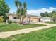 Traditional single-story home boasting a manicured lawn, colorful flowerbeds, and an attached two-car garage at 13003 Sandburst Ln, Hudson, FL 34667