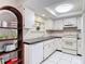 Bright kitchen featuring a dishwasher, white cabinetry, and ample counter space at 13003 Sandburst Ln, Hudson, FL 34667