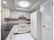 Clean kitchen with white appliances, a refrigerator, and convenient pantry access at 13003 Sandburst Ln, Hudson, FL 34667