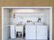 This laundry area includes washer, dryer, sink, cabinet space, and storage at 13003 Sandburst Ln, Hudson, FL 34667