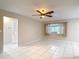 Open living room with tile flooring, ceiling fan, and large window, offering a bright and airy atmosphere at 13003 Sandburst Ln, Hudson, FL 34667