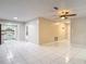 Spacious living room with tile flooring, ceiling fan, and access to the kitchen at 13003 Sandburst Ln, Hudson, FL 34667