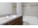 Bathroom boasts granite counters and a shower-tub combo with decorative tile surround at 13343 Sampson Ave, Brooksville, FL 34614