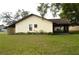 The backyard shows a well-maintained lawn, a screened porch, and a home with neutral color scheme and brown trim at 13425 Bonita Ave, Spring Hill, FL 34609