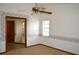 Bedroom with neutral carpet, floral wallpaper border, ceiling fan, and an adjoining bathroom at 13425 Bonita Ave, Spring Hill, FL 34609