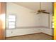Bedroom with neutral carpet, floral wallpaper border, ceiling fan, and two windows at 13425 Bonita Ave, Spring Hill, FL 34609