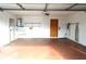 Clean, empty garage with white walls, open shelving, and space for storage at 13425 Bonita Ave, Spring Hill, FL 34609