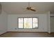 Bright living room with a ceiling fan and a large window offering natural light at 13425 Bonita Ave, Spring Hill, FL 34609
