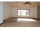Living room with ceiling fan and large window providing plenty of natural light at 13425 Bonita Ave, Spring Hill, FL 34609