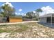 View of the backyard with a storage shed and partial fence with a covered patio to the home at 1402 Tallahassee Dr, Tarpon Springs, FL 34689