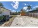 View of the backyard with a wooden shed and partial fencing with scattered foliage at 1402 Tallahassee Dr, Tarpon Springs, FL 34689