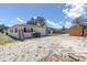 Exterior shot of the back of the house showing the stone landscaping and a wooden shed at 1402 Tallahassee Dr, Tarpon Springs, FL 34689