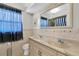Bathroom with double sinks, tiled walls, and a framed mirror at 1402 Tallahassee Dr, Tarpon Springs, FL 34689