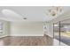Spacious living room with pristine hardwood floors and a sliding glass door to the backyard at 1402 Tallahassee Dr, Tarpon Springs, FL 34689