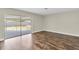 Spacious living room with wood-look flooring and sliding glass doors to the patio at 1402 Tallahassee Dr, Tarpon Springs, FL 34689
