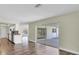 Open concept living room with wood-look floors and sliding glass doors to the patio at 1402 Tallahassee Dr, Tarpon Springs, FL 34689