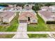Aerial view of a home with a backyard pool, well-maintained lawn, and a surrounding neighborhood at 15205 Durango Cir, Brooksville, FL 34604