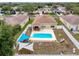 Aerial view showcases the pool, covered patio, fenced yard, and shade sails at 15205 Durango Cir, Brooksville, FL 34604