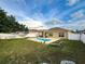 Spacious backyard features a refreshing in-ground pool, covered patio, and green lawn at 15205 Durango Cir, Brooksville, FL 34604