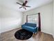 Bedroom with wood-look flooring, a ceiling fan, and a comfortable blue sofa at 15205 Durango Cir, Brooksville, FL 34604