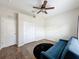 Comfortable bedroom with wood-look flooring, ceiling fan, and blue sofa at 15205 Durango Cir, Brooksville, FL 34604