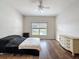 This spacious bedroom features wood floors, a ceiling fan, and a large window with a view of the pool at 15205 Durango Cir, Brooksville, FL 34604