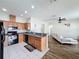 Open concept kitchen with stainless steel appliances and breakfast bar, adjacent to a living area with wood floors at 15205 Durango Cir, Brooksville, FL 34604