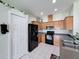 Bright kitchen featuring wooden cabinets, black appliances, and tile flooring for a clean and modern look at 15205 Durango Cir, Brooksville, FL 34604