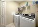 Laundry room with modern washer and dryer, and storage shelves at 15205 Durango Cir, Brooksville, FL 34604