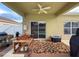 Covered patio with ceiling fan, patterned rug, and sliding glass doors leading to the pool at 15205 Durango Cir, Brooksville, FL 34604