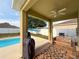 Relaxing covered patio area with a wooden swing and outdoor grill overlooking the pool at 15205 Durango Cir, Brooksville, FL 34604