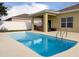 Backyard pool with a patio and white fence, perfect for outdoor relaxation and entertaining in a sunny setting at 15205 Durango Cir, Brooksville, FL 34604