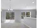 Bright dining area featuring tile floors, sliding glass doors to backyard, and a stylish modern chandelier at 15291 Green Jay Rd, Weeki Wachee, FL 34614