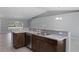 Kitchen featuring a breakfast bar with a stainless steel dishwasher, sink, and faucet, as well as dark wood cabinets at 15291 Green Jay Rd, Weeki Wachee, FL 34614