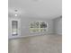 Empty living room with neutral tile flooring, arched front window and stained-glass front door provides a canvas for new owners at 15291 Green Jay Rd, Weeki Wachee, FL 34614