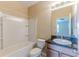 Bathroom with a shower-tub combo, white toilet, vanity with sink, and a framed mirror with vanity lighting at 15846 Stable Run Dr, Spring Hill, FL 34610