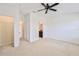 Large bedroom boasts neutral walls, carpet flooring, access to a closet and ensuite bathroom, and a ceiling fan at 15846 Stable Run Dr, Spring Hill, FL 34610