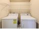 Laundry room featuring a washer, dryer, and wire shelving, providing a functional space for laundry tasks at 15846 Stable Run Dr, Spring Hill, FL 34610