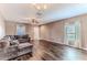 Inviting living room with hardwood floors, ceiling fan, and a large sectional sofa with throw pillows at 15846 Stable Run Dr, Spring Hill, FL 34610