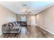 Bright living room featuring hardwood floors, a ceiling fan, and a comfy gray sectional sofa at 15846 Stable Run Dr, Spring Hill, FL 34610