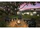 Backyard features a fire pit and a screened in pool in the background, great for relaxing at 18644 Autumn Lake Blvd, Hudson, FL 34667
