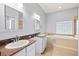 Bathroom featuring double vanity, soaking tub, and natural light from glass block window at 18644 Autumn Lake Blvd, Hudson, FL 34667