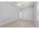 Neutral carpeted bedroom with a ceiling fan, white trim, and ample closet space at 18644 Autumn Lake Blvd, Hudson, FL 34667
